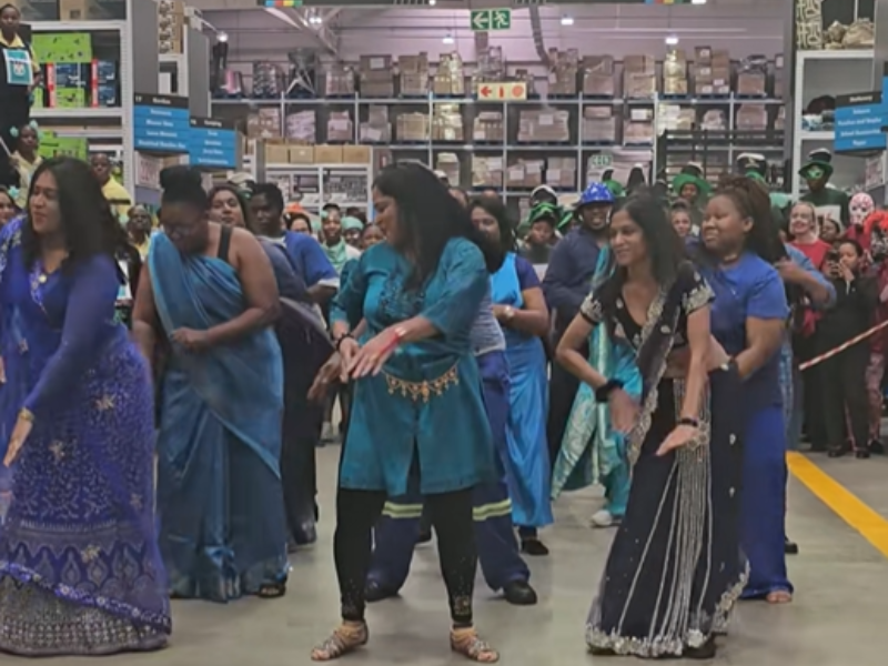 A group of people dance in the middle of a store