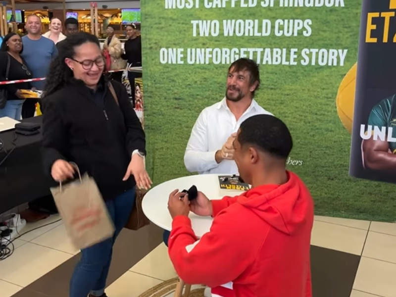 A guy proposes to his partner at the Eben Etzebeth book launch