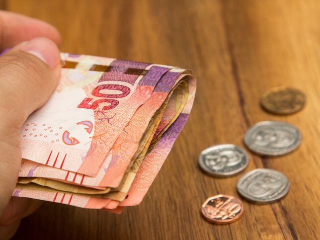 A hand holding South African money iStock