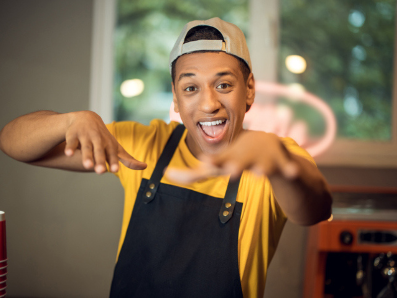 A happy cafe worker having fun at the coffee shop