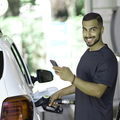A happy man fueling his car with petrol