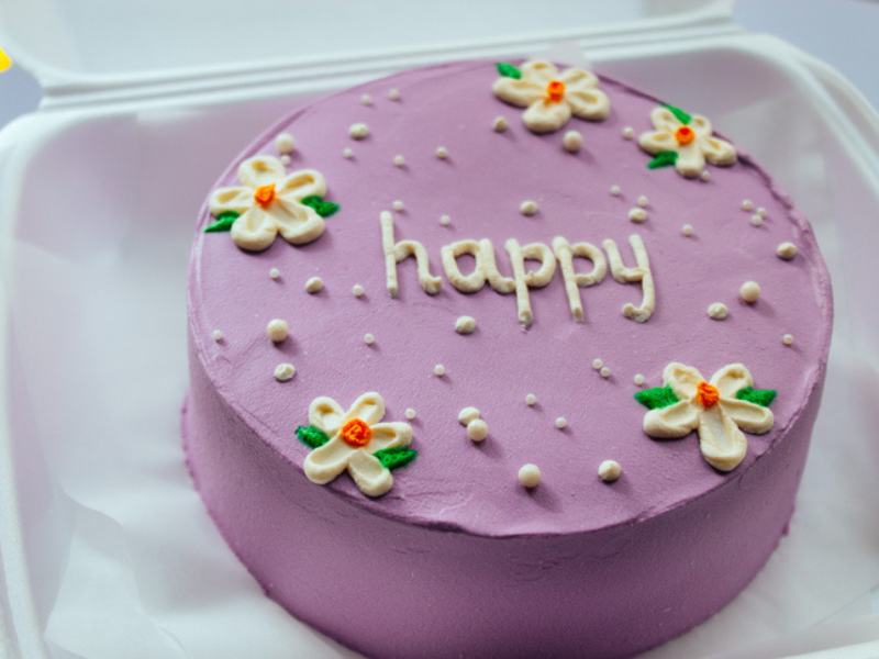 A holiday bento cake with the word happy written on it