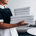 A hotel staff member carries freshly folded towels