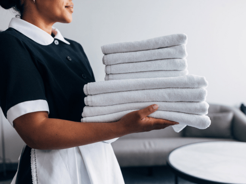 A hotel staff member carries freshly folded towels