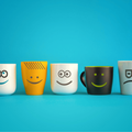 A line of coffee mugs with different emoticons on them