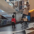 A little boy dances while his father plays the violin
