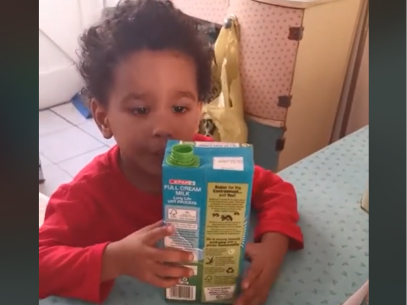 A little boy holding a SPAR brand long life milk carton