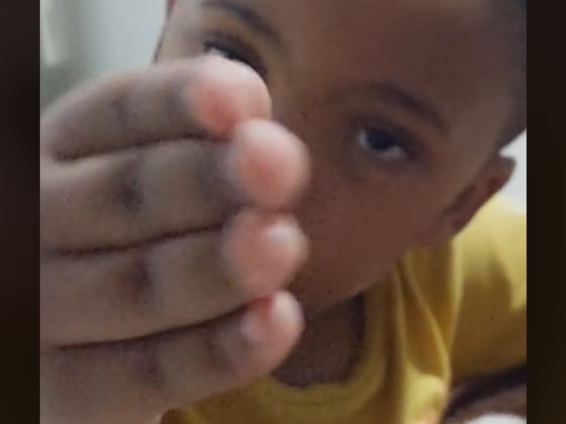 A little boy uses his hand to express himself