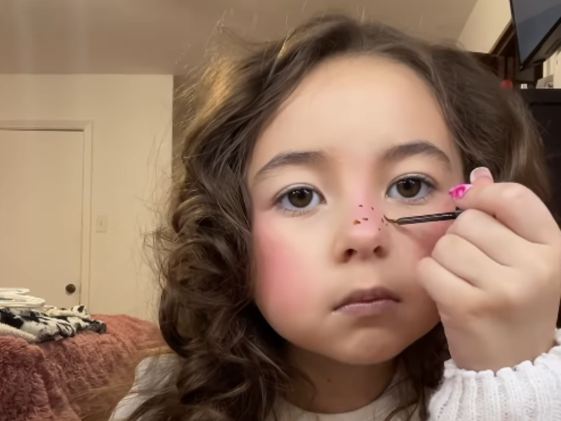 A little girl puts makeup on in a get ready with me video