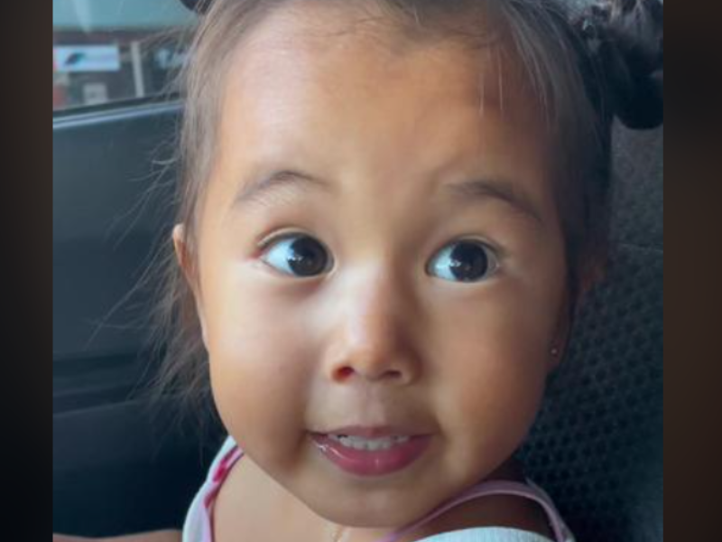 A little girl talking to mom in car