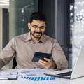 A male accountant smiles while working at his desk