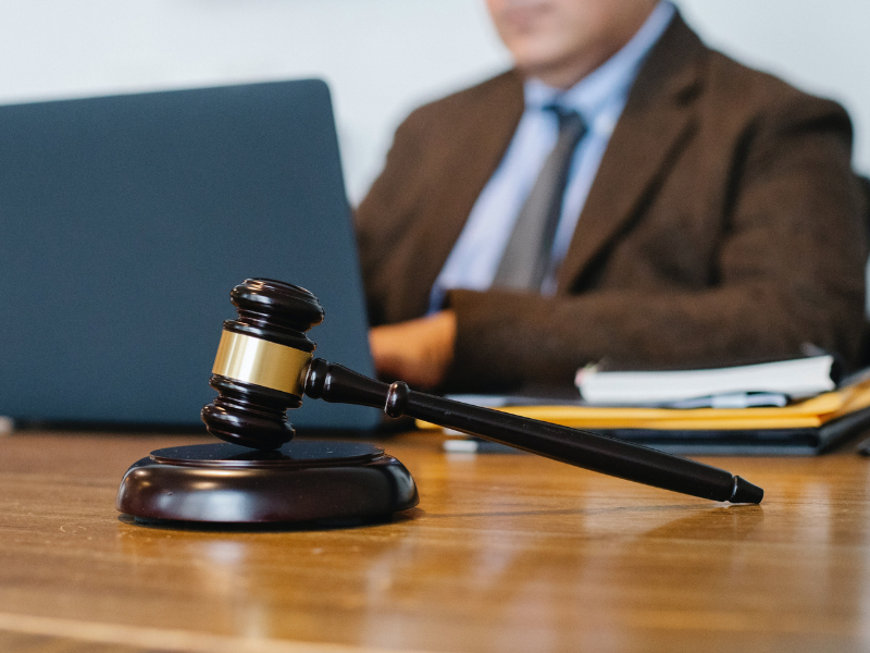 A male judge working on a laptop in office in front of gaval