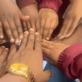 A male teacher gathers hands with his pupils