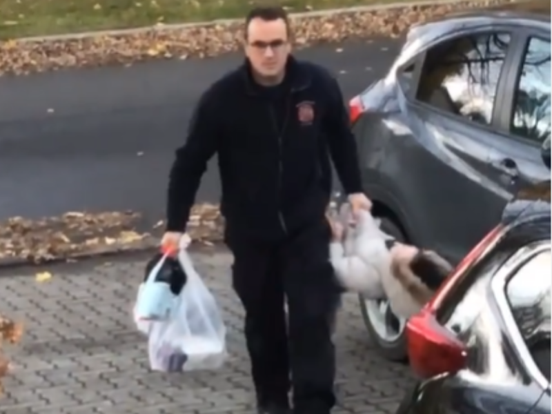 A man carrying his kid like a grocery bag