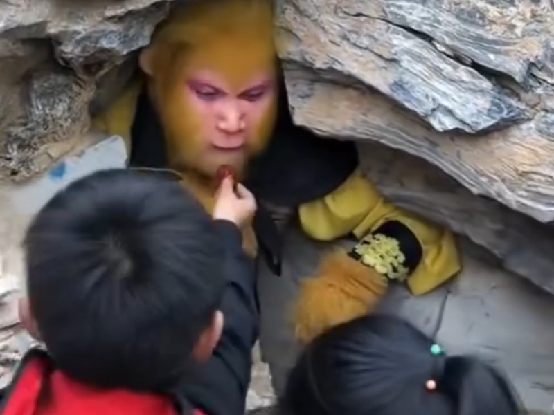 A man dressed like a monkey eating food from people