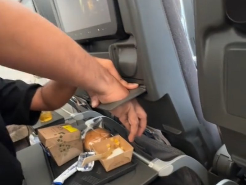 A man gets hand stuck inside a cup holder during his flight