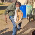 A man grabs a bag of cement with his mouth