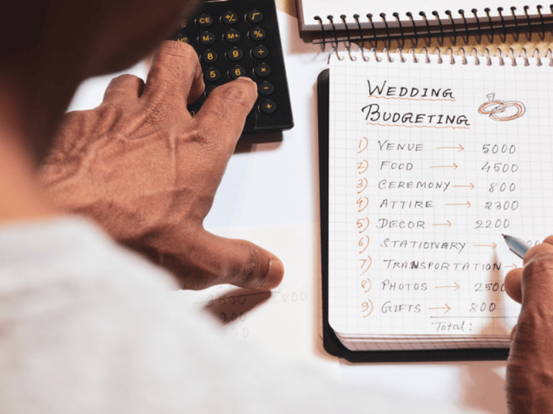 A man hand calculating the wedding expenses