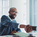 A man happily shakes hands with another person