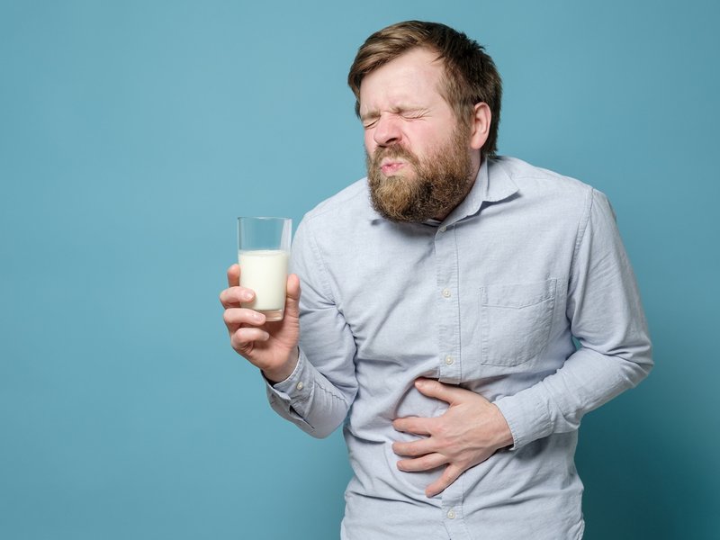 A man holds a glass of milk