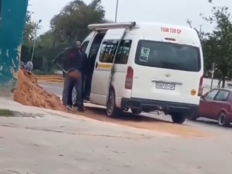 A man is loading sand into a passenger taxi