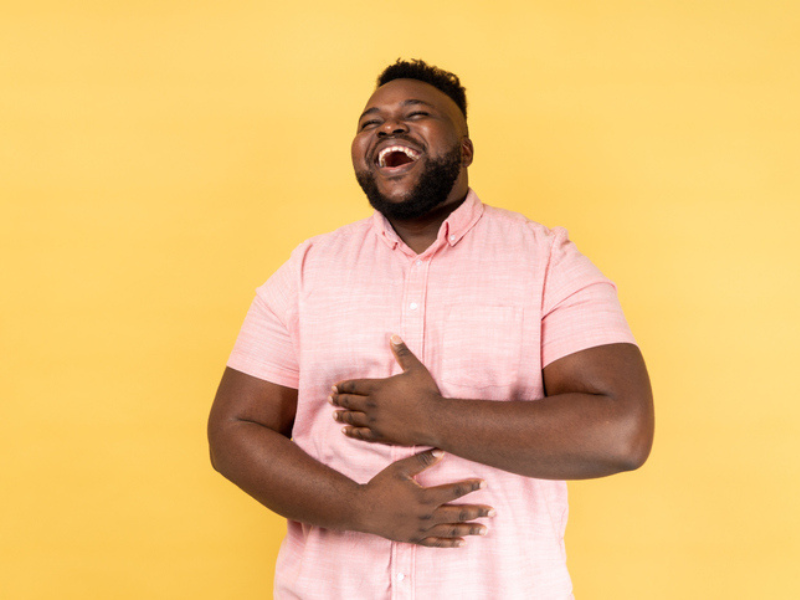 A man laughing out loud holding his belly