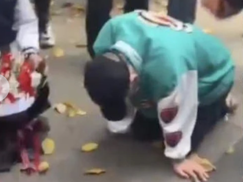 A man on bended knees outdoors