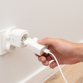 A man plugs in a charger into a smart socket