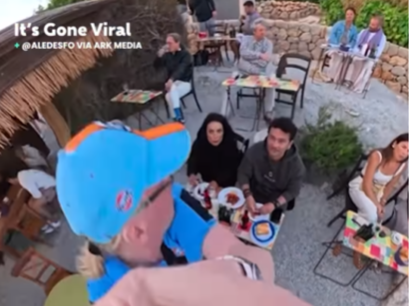 A man removes a couples phone tripod at a restaurant