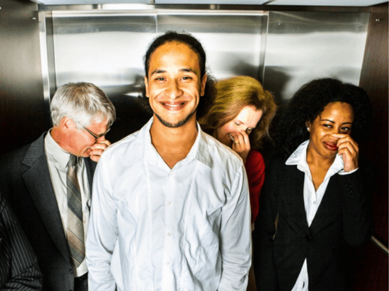 A man in a lift while people hold their noses