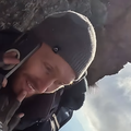 A man talking on the phone during a mountain climb