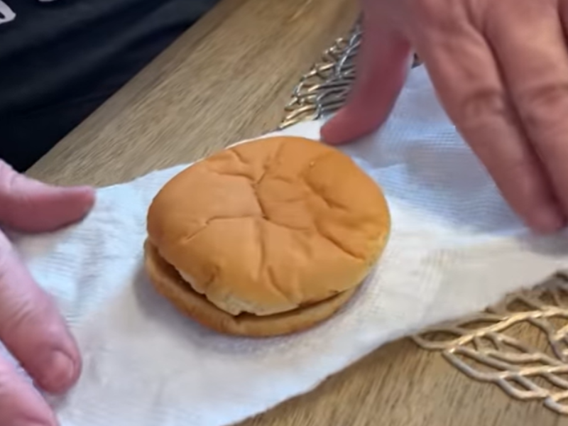 A man unfolds an old burger