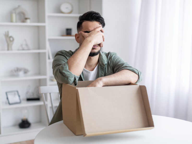 A man upset after opening a parcel