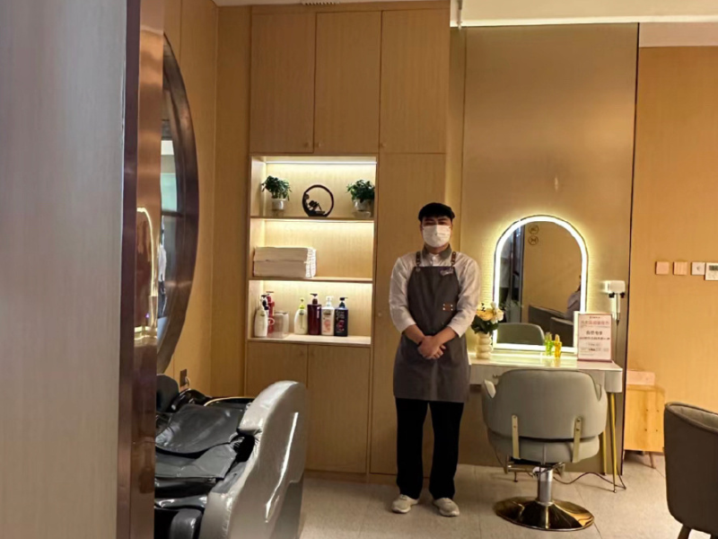 A man wearing a mask at a hair washing station