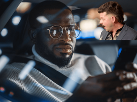 A man wearing glasses looks at his smartphone inside car
