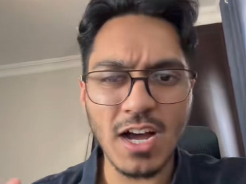 A man wearing spectacles looks frustrated