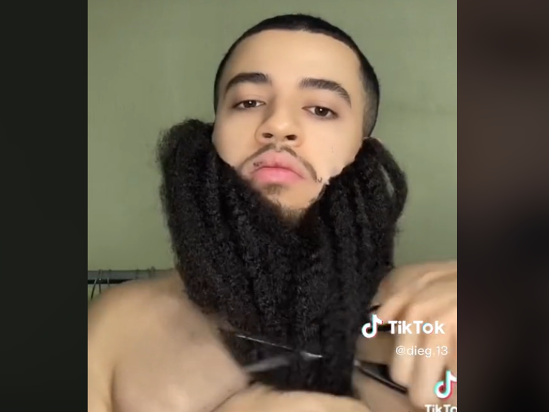 A man with fake beard and scissor