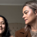 A mother and daughter chat with one another in a room