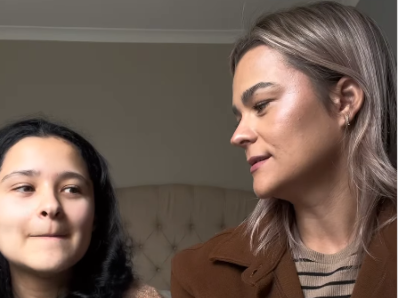 A mother and daughter chat with one another in a room