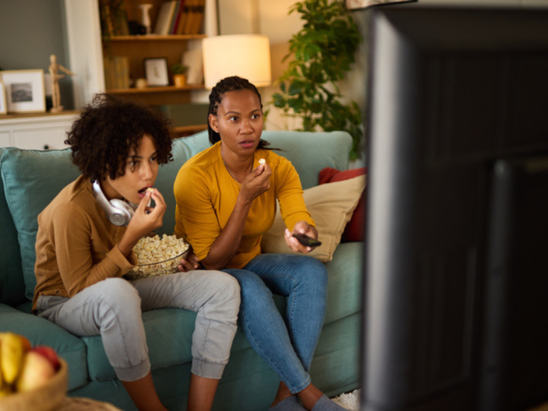 A mother and son watching a scary movie on TV
