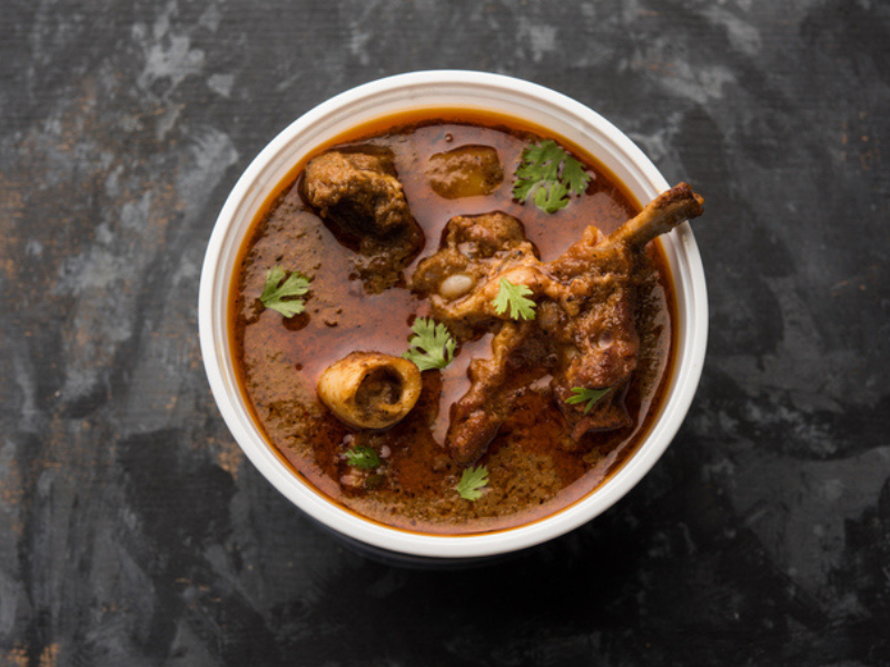 A mutton masala curry in a plastic container