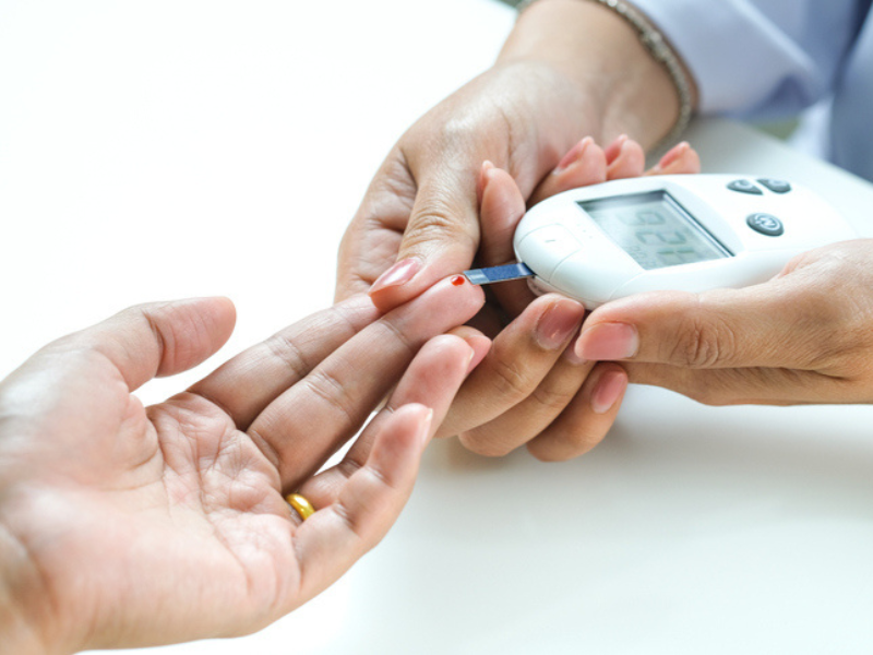 A person checks another persons blood sugar levels