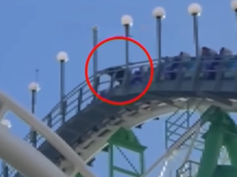 A person climbs out of a rollercoaster while it ascends