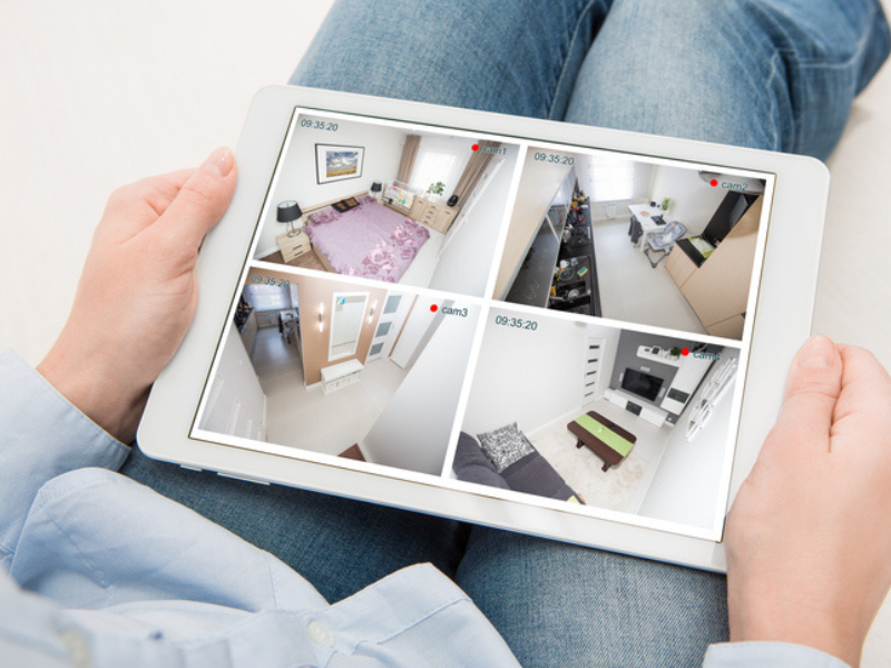 A person holding a home camera monitoring system