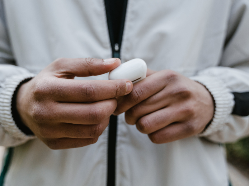 A person holding earpods