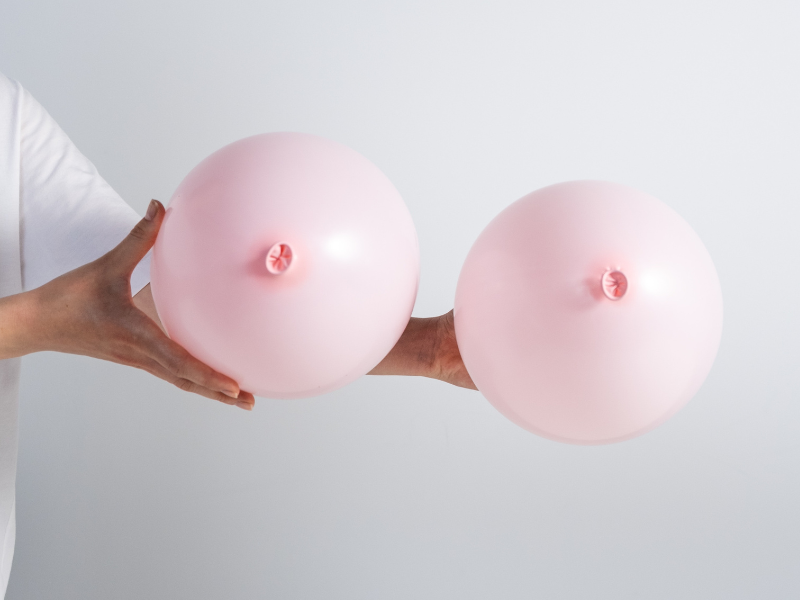 A person holding pink balloons