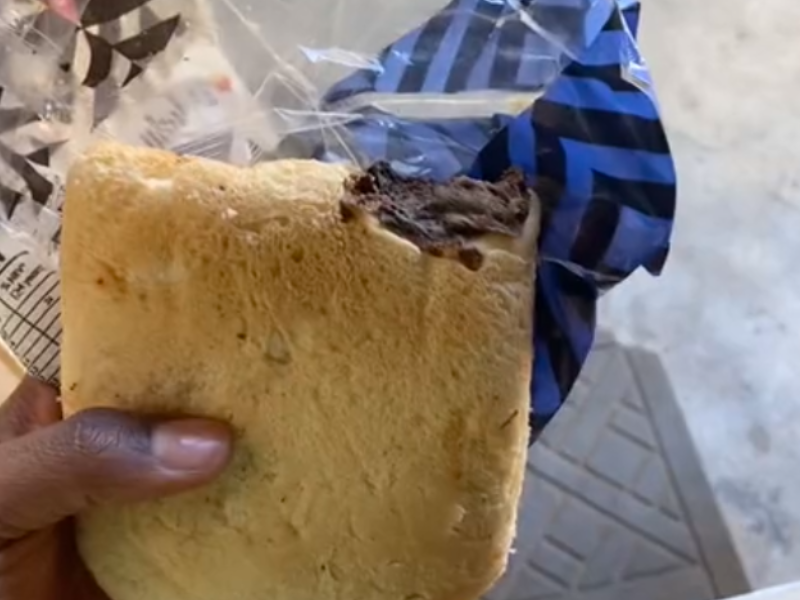 A person holds a slice of Sasko bread with something baked into it