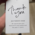 A person holds a thank you note attached to a small chocolate