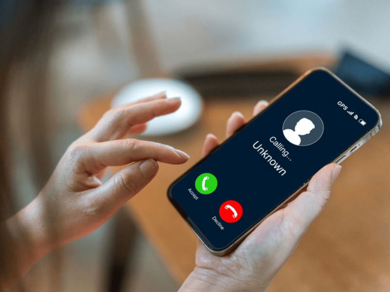 A person holds up a smartphone about to answer a call from an unknown number