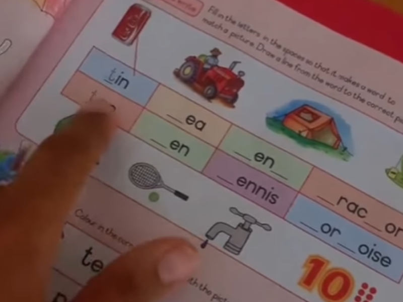 A person points to the homework book exercise